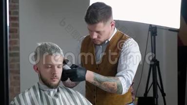 去理发。 理发店里坐在椅子上时，一个留胡子的年轻人在理发店理发。